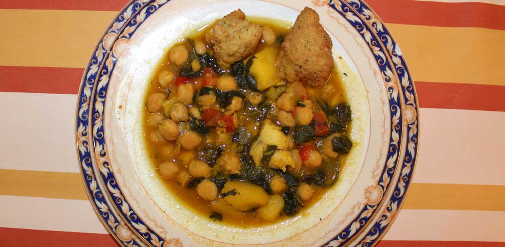 Un plato de potaje con panezuelos sobre un mantel