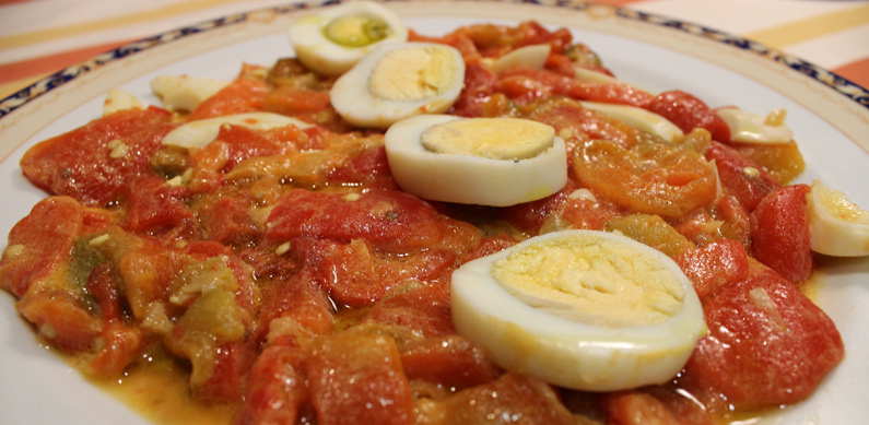 Plato de pimientos rojos con huevo duro por encima